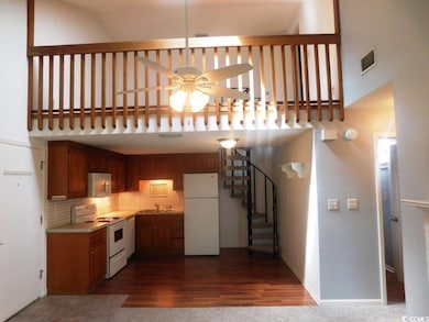 Kitchen with white appliances, ceiling fan, a towering ceiling, backsplash, and light countertops