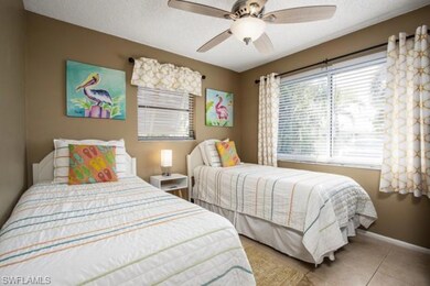Bedroom featuring a textured ceiling, light tile patterned flooring, and a ceiling fan