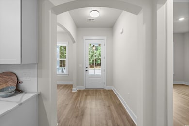 Doorway to outside with wood finished floors and arched walkways