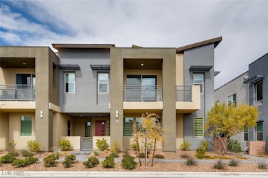 View of front of home with stucco siding and a bal