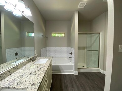 Full bath featuring vanity, a stall shower, wood f
