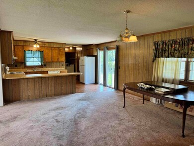 Kitchen featuring light carpet, kitchen peninsula,