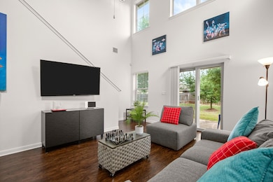 Living room with wood finished floors, a towering
