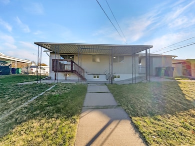 Back of house with a lawn and a patio