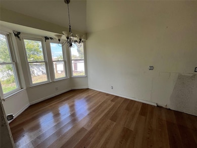 Unfurnished dining area with a chandelier and wood finished floors