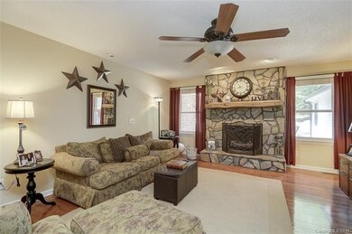 Family room features stone fireplace with rustic m