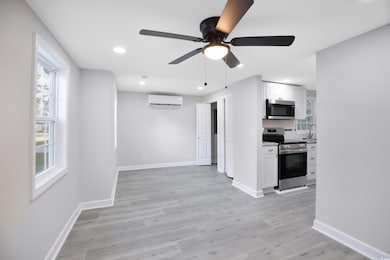 Kitchen featuring appliances with stainless steel finishes, light wood finished floors, a ceiling fan, white cabinetry, and recessed lighting