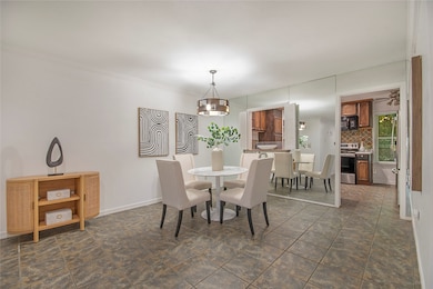Dining room featuring ornamental molding and dark tile patterned floors