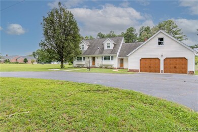 Cape cod house featuring a garage and a front lawn
