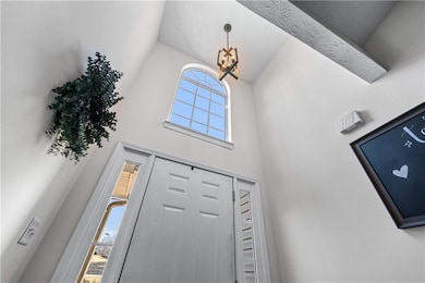 Foyer with a chandelier and high vaulted ceiling