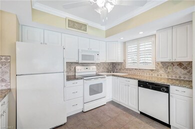 Kitchen featuring white appliances, crown molding, backsplash, white cabinetry, and light tile patterned flooring