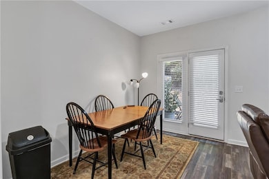 Dining space with baseboards and dark wood-style flooring