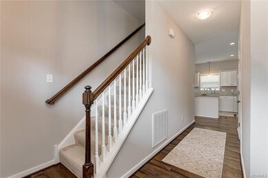 Hallway to kitchen with half bath on right