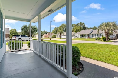Covered porch with a residential view and a lawn