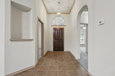 Entrance foyer featuring crown molding, dark tile 