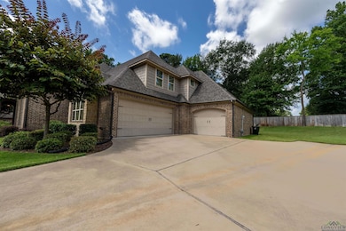 View of front facade with roof with shingles, an attached garage, driveway, and brick siding