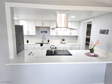 Kitchen with freestanding refrigerator, white cabi
