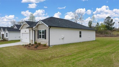 View of property exterior featuring driveway, a yard, an attached garage, and stone siding