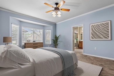 Bedroom with carpet floors, crown molding, basebo