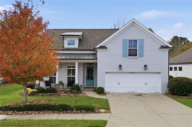 View of front of home featuring a porch, brick siding, an attached garage, driveway, and a shingled roof