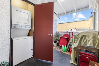 Laundry area with stacked washer / drying machine, carpet floors, and laundry area
