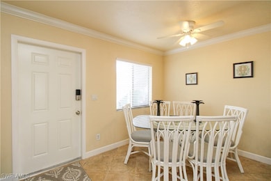 Dining space with ornamental molding, ceiling fan, and light tile patterned floors