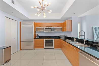Kitchen with stainless steel appliances, a sink, modern cabinets, and a chandelier