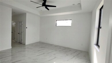 Unfurnished room with ceiling fan and a raised cei
