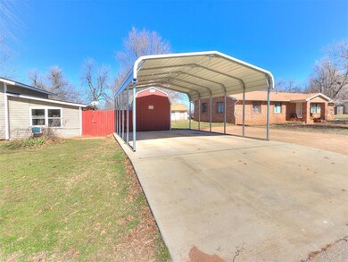 View of parking featuring a carport, concrete driv