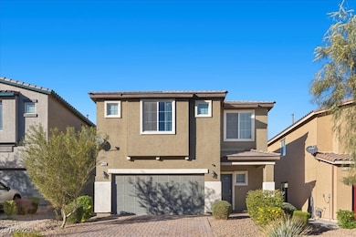 Traditional-style home with a tiled roof, stucco siding, decorative driveway, and an attached garage