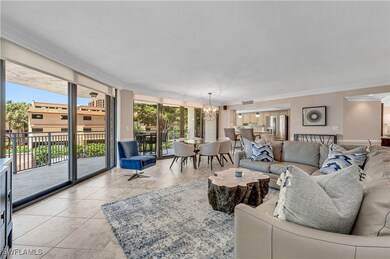 Tiled living room featuring a chandelier, crown molding, and floor to ceiling windows