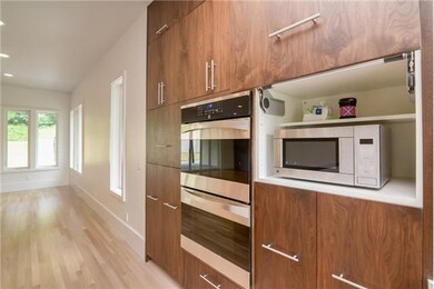 Microwave is hidden to the right of the double ovens and a coffee bar is on the left