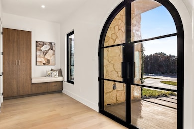 Hallway with light wood-style flooring and recessed lighting
