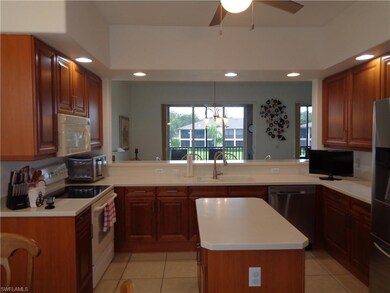 Kitchen with appliances with stainless steel finishes, recessed lighting, light countertops, light tile patterned floors, and a kitchen island
