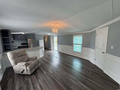 Living room with a textured ceiling, a chandelier,
