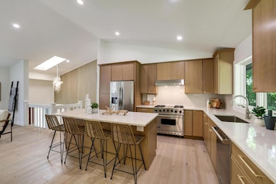 Stunning brand-new kitchen features beautiful cabinets, center island, large kitchen window under soaring vaulted ceilings, stunning wood floors, sky lights AND SO MUCH MORE!