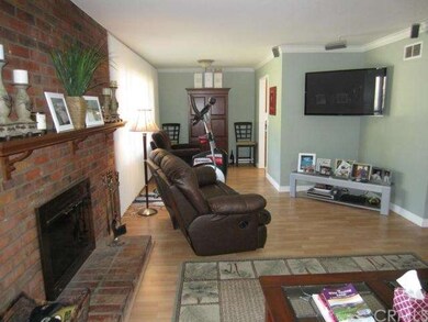 Living Room with Brick Fireplace and Laminate Floo