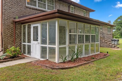 View of side of property with a sunroom and a lawn
