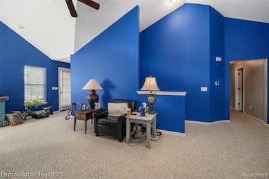 Sitting room featuring high vaulted ceiling, carpet, and a ceiling fan