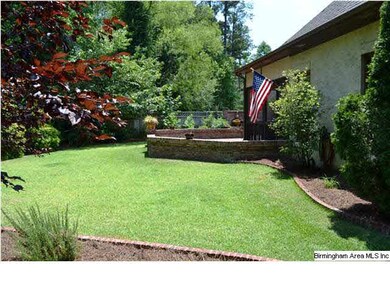 Beautifully landscaped back yard featuring a lush 