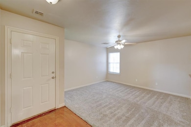 Empty room featuring ceiling fan and light carpet