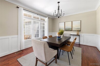 Dining area with dark wood-type flooring, a chande