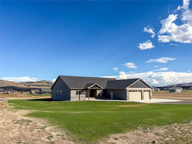 View of front of home with stone siding, a front lawn, an attached garage, roof with shingles, and concrete driveway