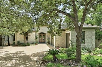 View of front facade with driveway, an attached garage, french doors, and stucco siding