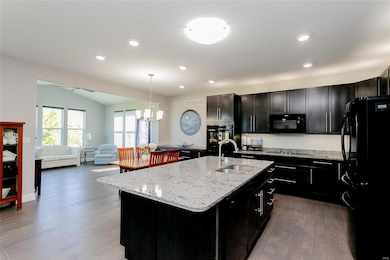 Gourmet kitchen open to sun room features hardwood