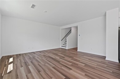 Empty room with stairway, wood finished floors, and baseboards