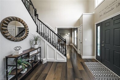 Entrance foyer featuring a high ceiling and hardwo