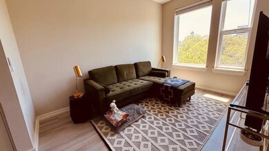 Living area featuring baseboards and light wood f
