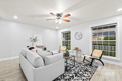 Living room with a ceiling fan, wood tiled floors, a textured ceiling, and recessed lighting
