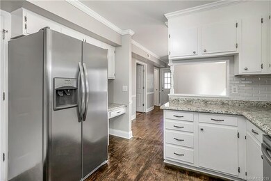 Kitchen features a built in desk and flows into th